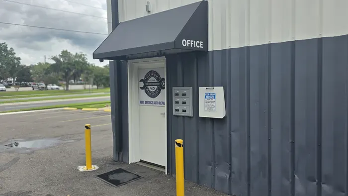 The Oviedo Car Care office door under its black awning, with the white key-drop box mounted beside it