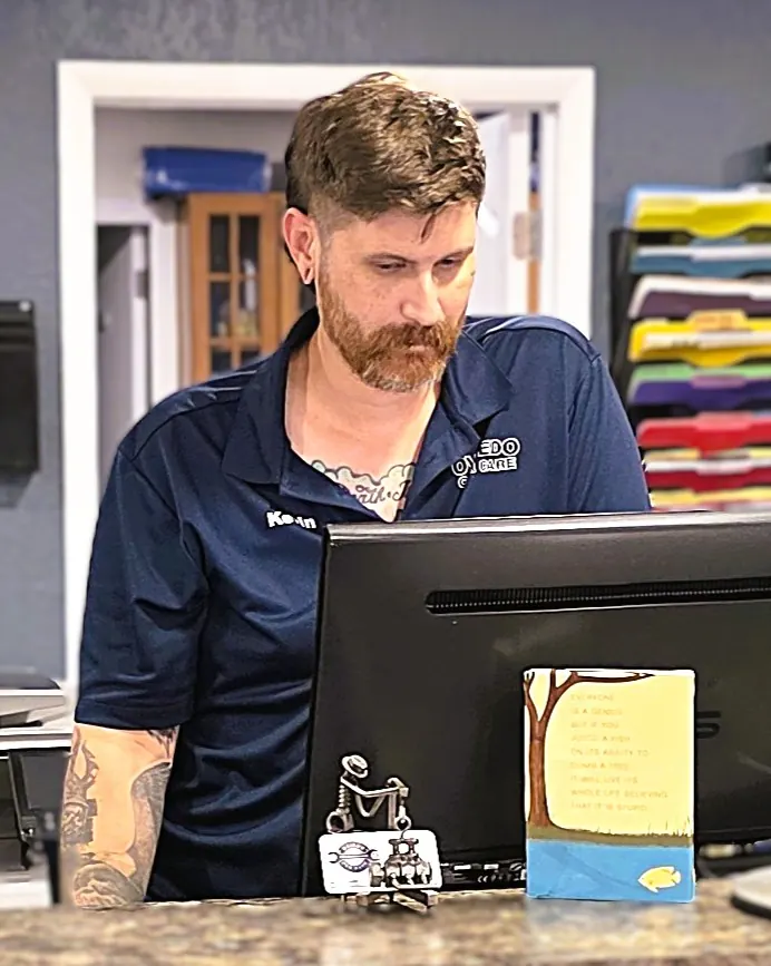 Kevin at the front counter at Oviedo Car Care, focused on his screen